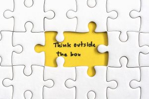 Kumpulan puzzle yang dibelakangnya bertuliskan 'Think outside the box', menunjukkan bahwa brand harus memiliki USP dengan berpikir di luar kotaknya.