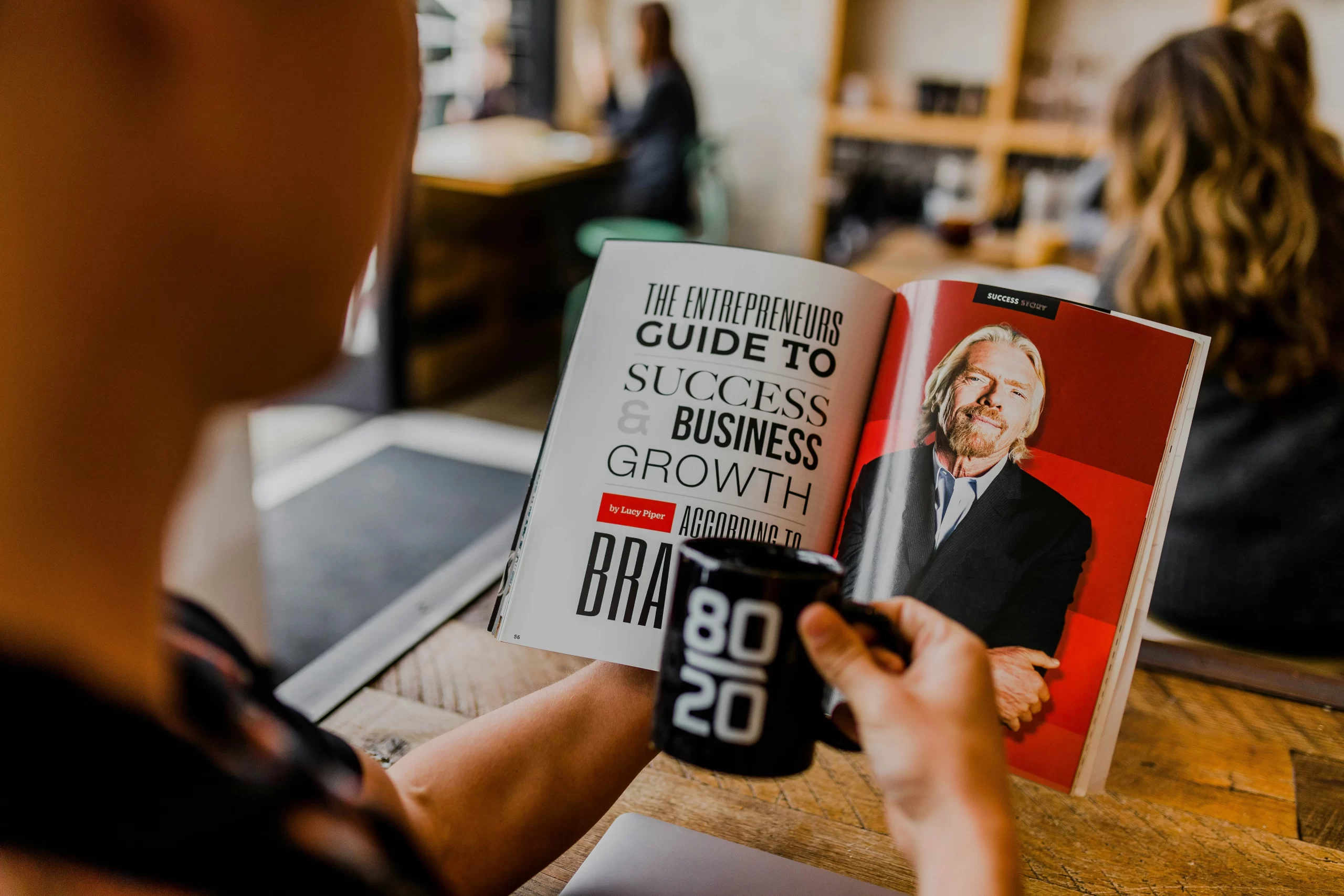 A person reading a book about Richard Branson, symbolizing a desire to learn from successful entrepreneurs.